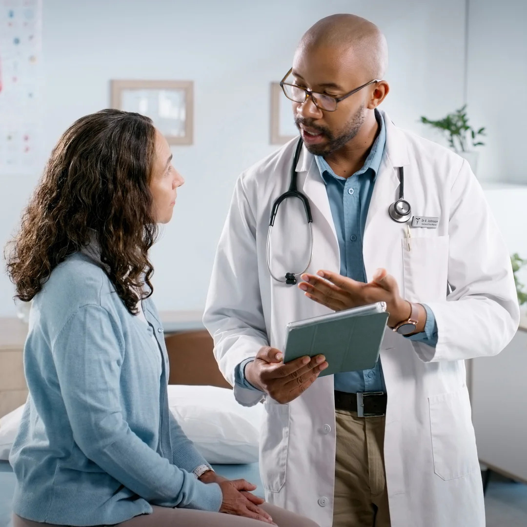 Doctor holds a tablet and explains something to a patient
