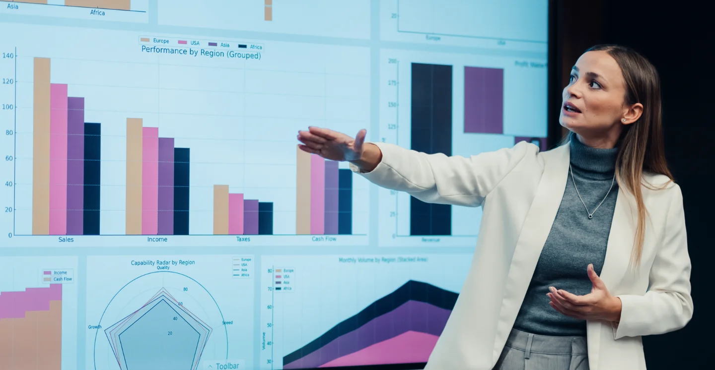 Business leader presenting data visualizations on a large digital dashboard during a financial transformation discussion
